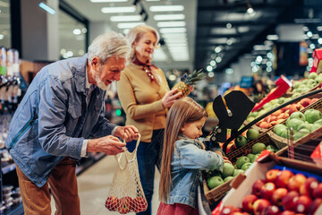 Cute little girl shopping with grandparents - obrazy, fototapety, plakaty
