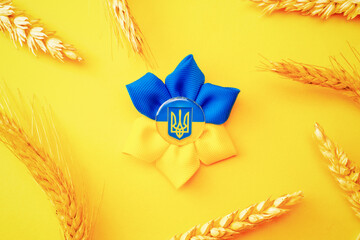 Ukraine background. Ukrainian flower trident symbol with wheat grain ear isolated on yellow banner....