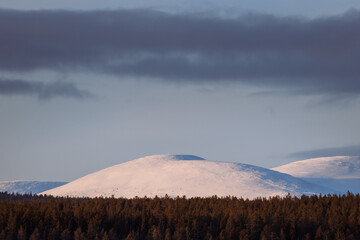 snow capped mountains during golden hour in finnish lapland during winter 