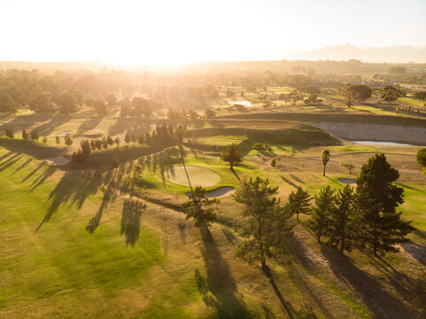 Aerial scenic view of lush landscape and bright sun against clear sky during sunset, copy space