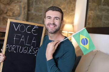 Portuguese teacher holding blackboard and Brazilian flag. TRANSLATION OF THE TEXT IN THE IMAGE: 