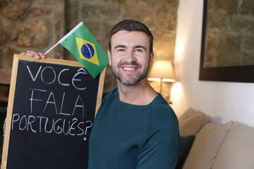 Portuguese teacher holding blackboard and Brazilian flag. TRANSLATION OF THE TEXT IN THE IMAGE: 