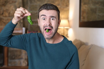 Man eating a spicy green jalapeño