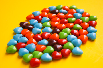 View from above on a multi-colored dragee in the shape of hearts.