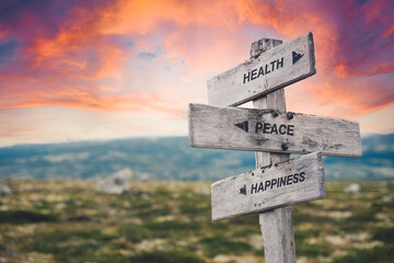 health peace happiness text quote caption on wooden signpost outdoors in nature. Stock sign words theme.