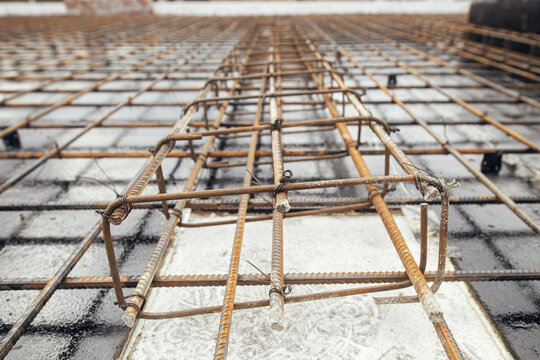Steel Rebar Mesh Close Up. Reinforcement Rods At Construction Site. Rusty Steel Reinforcement Bars For Concrete Foundation Or Ceiling. Process Of House Building