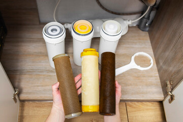 Plumber installs or change water filter. Replacement aqua filter. Repairman installing water filter...