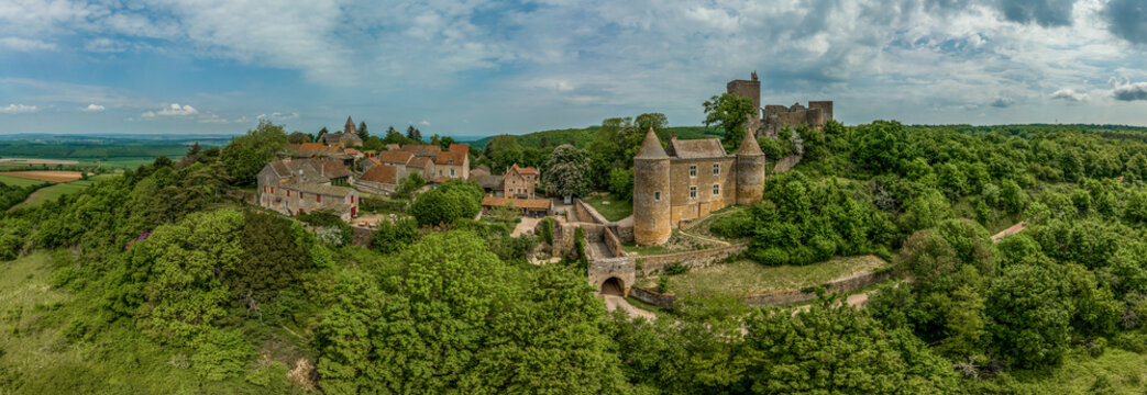 Aerial view of Brancion castle and medieval village in Burgundy France with square keep, ruined palace building and encircling medieval walls