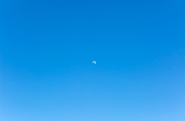 The texture of the blue sky with the moon in the middle. Day