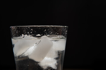 glass of water with ice on a black background