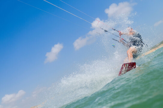 Brave man kitesurfing in the waves of the Mediterranean Sea on a sunny day