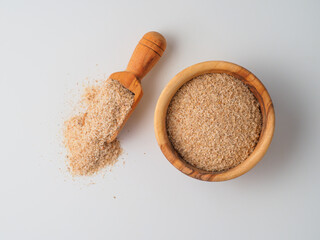 Psyllium husk in the plate with spoon on white background.