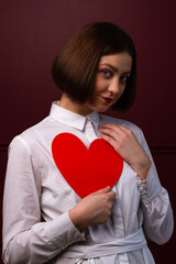 Short-haired woman holding heart shape in front of her chest