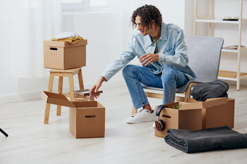 portrait of a man unpacking things from boxes in the room interior