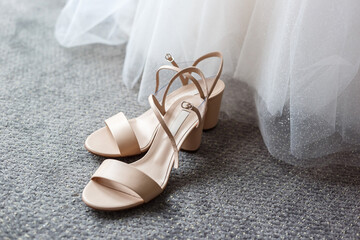 Elegant shoes on the background of a white wedding dress. 