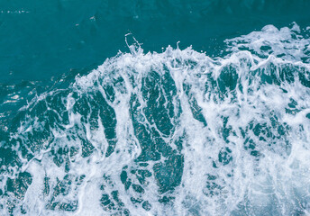 Beautiful sea waves with foam of blue and turquoise color. Abstract blue sea water with white wave. Blue and white waves of the ship road on the water sea ocean.