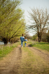 Fototapeta premium Two cute sister girls are running down an empty country road. Spring. Freedom. Childhood. Family.