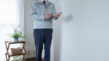 マンションの部屋を点検する作業服の男性｜リフォーム調査・見積り