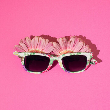 Bloosoming sunglasses on a pink background.Top view