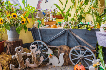 Concrete art figures presented with old handcarts and sunflowers