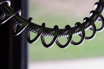Close-up shot of a black, metal coil isolated on a blurred background