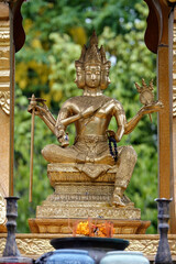 Vertical shot of a golden goddess statue in a spirit house in Chiang Mai, Thailand