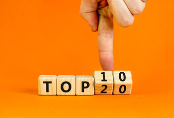 From Top 20 to 10 symbol. Businessman turns wooden cubes and changes concept words Top 20 to Top...