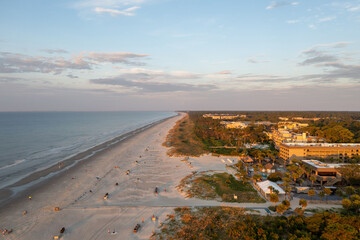 View of Coligny beach on Hilton Head Island.Ocean view at sunset with trees and hotels in foreground - obrazy, fototapety, plakaty