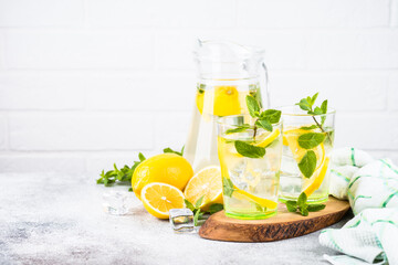 Lemonade in two glasses at white table.