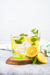 Lemonade in two glasses at white table.