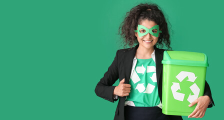Woman dressed as eco superhero with trash bin on green background. Concept of recycling