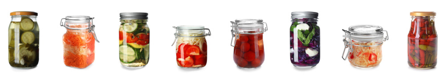 Set of jars with canned vegetables on white background
