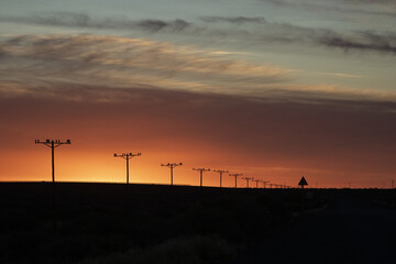 Row of utility poles outdoors during a breathtaking sunset