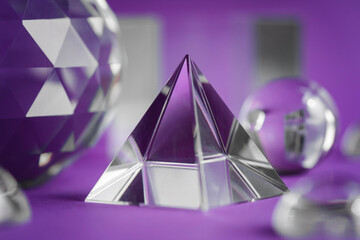Crystal prism refracting light, magic crystals and pyramid, sphere and cube on purple background....