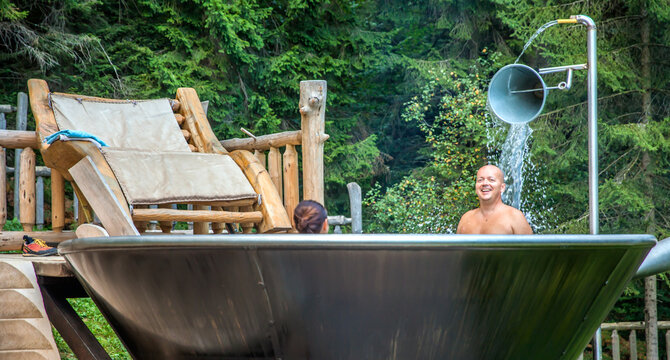 Couple enjoying a good bath in a unique jakuzzi at Hija Glamping Lake Block in Nova Vos, Slovenia