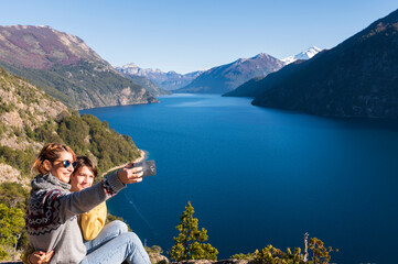 Mother and son having a sealie in the landscapes of Bariloche, Argentina. - obrazy, fototapety, plakaty