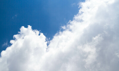 Summer sky. Cumulus clouds on a blue background. Partly cloudy.