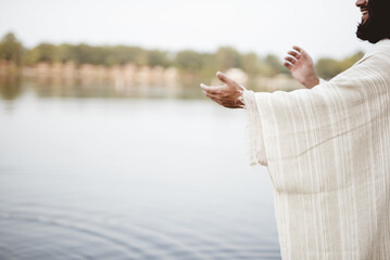 Closeup shot of a person wearing a biblical robe with his hands up
