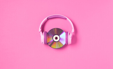 Pink youth headphones music cd discs on a pink background, flat lay copy space. Hobby entertainment technology