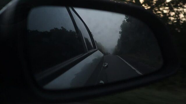 Side road view from the sidecar mirror in the early morning time with fog