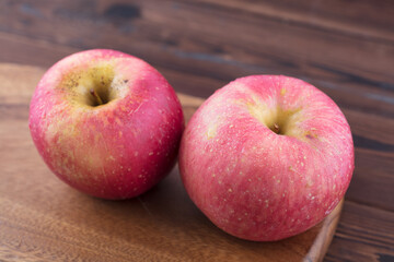 Two red apples on a cutting board