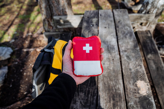 Red first aid kit with medicines, tourist equipment bag with medicines, first aid in the forest in nature, camping medicine.