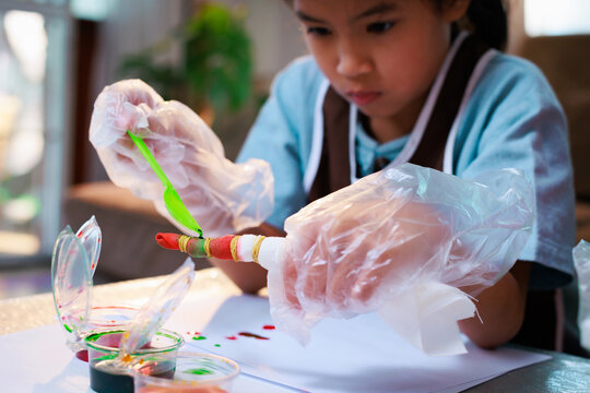 Asian Child Girl Enjoy Making Tie Dye Cloth At Home. Art And Craft DIY For Kid Concept.