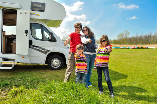 Family vacation, RV travel with kids, happy parents with children have fun on holiday trip in motorhome, camper van exterior