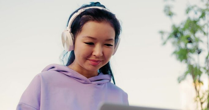 Asian woman freelancer outdoors working on laptop