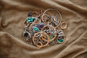 Bunch of stolen jewelry on military uniform cloth fabric. Looting by Russian soldiers in the...