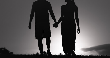 silhouette of a couple in the park holding hands 