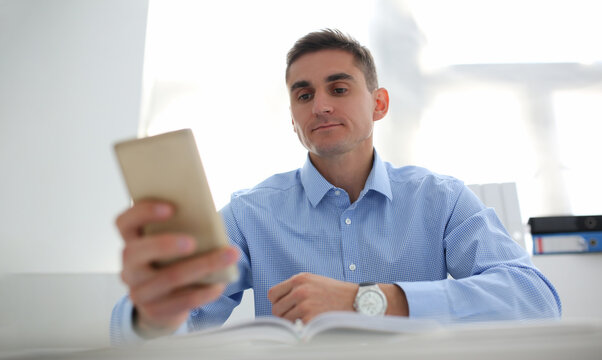 Concentrated worker using smartphone, chatting or surfing on internet