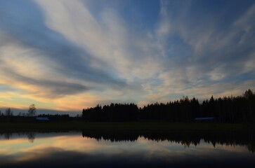 Fototapeta na wymiar sunset on the river, reflection of the forest at sunset, sunset on the forest lake