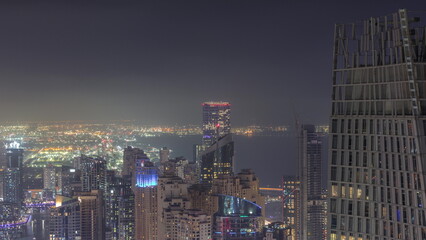 Aerial view of JBR and Dubai Marina skyscrapers and luxury buildings night timelapse from above